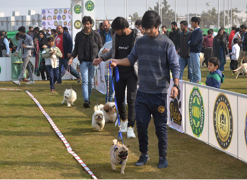 Handlers running with Dogs during the international all-breed championship Dog Show in collaboration with Pakistan Kennel Union at DHA