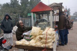 Vendor roasting popcorn to attract the customers at Qasim Bagh