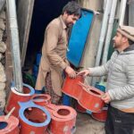 A vendor selling a traditional steel fire stove to the customer at his work place