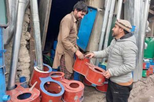 A vendor selling a traditional steel fire stove to the customer at his work place