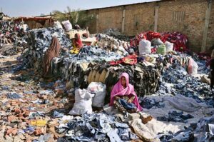 Labourer women arranging and sorting old clothes at site area.
