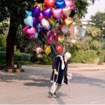 A disable vendor displaying the colorful balloons to attract the customers at roadside