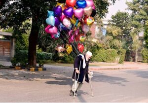 A disable vendor displaying the colorful balloons to attract the customers at roadside