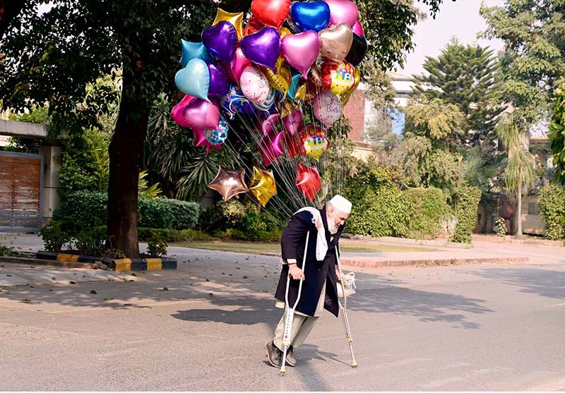 A disable vendor displaying the colorful balloons to attract the customers at roadside