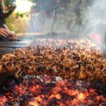 A vendor preparing traditional food item for customers at KhanaPul