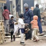 Youngsters collecting wood pieces for domestic use at the timber market