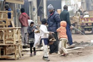 Youngsters collecting wood pieces for domestic use at the timber market