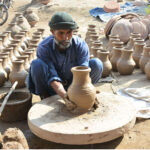 A worker busy in preparing the clay-made pots at his workplace