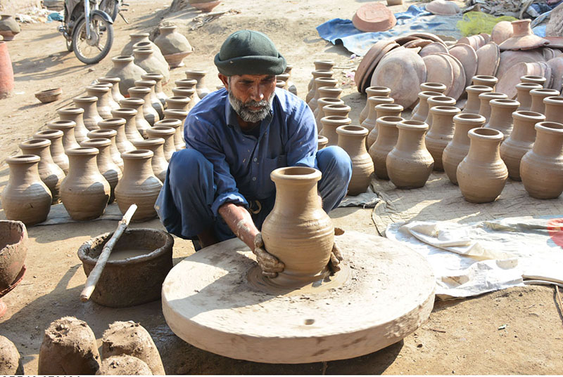 A worker busy in preparing the clay-made pots at his workplace