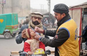 Health worker administering polio drops to child during anti-polio campaign in the city