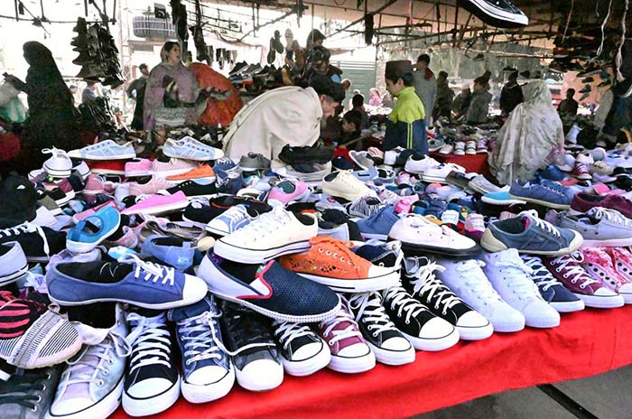 Vendor displaying shoes to attract the customer at Bacha Khan Chowk.