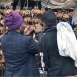 People are busy selecting and purchasing name key-rings from roadside vendor