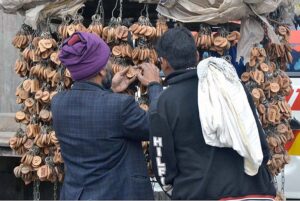 People are busy selecting and purchasing name key-rings from roadside vendor