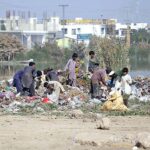 Gypsy youngsters searching and collecting recycle items from heap of garbage near Qasim Chowk.