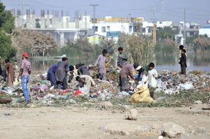 Gypsy youngsters searching and collecting recycle items from heap of garbage near Qasim Chowk.