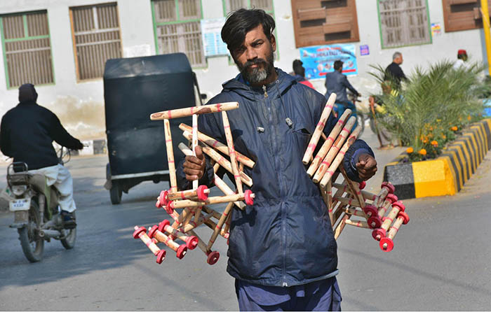 A vendor displaying wooden toys to attract the customers at Cantonment Road.