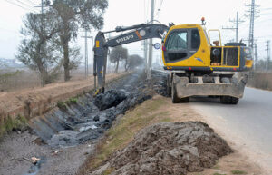 Worker is busy cleaning the Canal with the help of Machinery at the old Shujaabad road. 