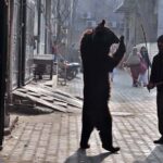 A juggler is showing gimmicks of bear to entertain the people in the street at Shamsher Town.