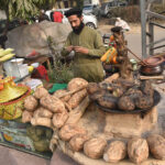 A vendor selling Sweet potatoes at his roadside setup in the city
