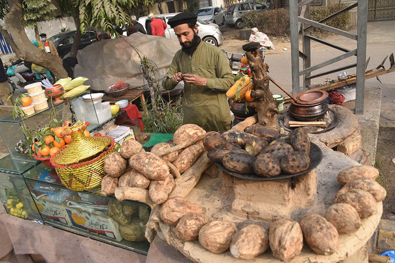 A vendor selling Sweet potatoes at his roadside setup in the city