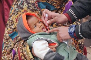 Health worker administering polio drops to child during anti-polio campaign in the city