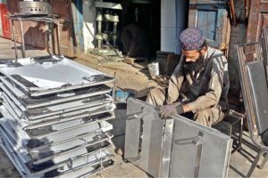 A skilled person making steel pipe and other items for the firewood stove at his work place as per increased demand in winter session.