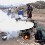 Farmer busy in boiling sugarcane juice for making traditional gur and brown sugar (Shakar) at Bosan Road.