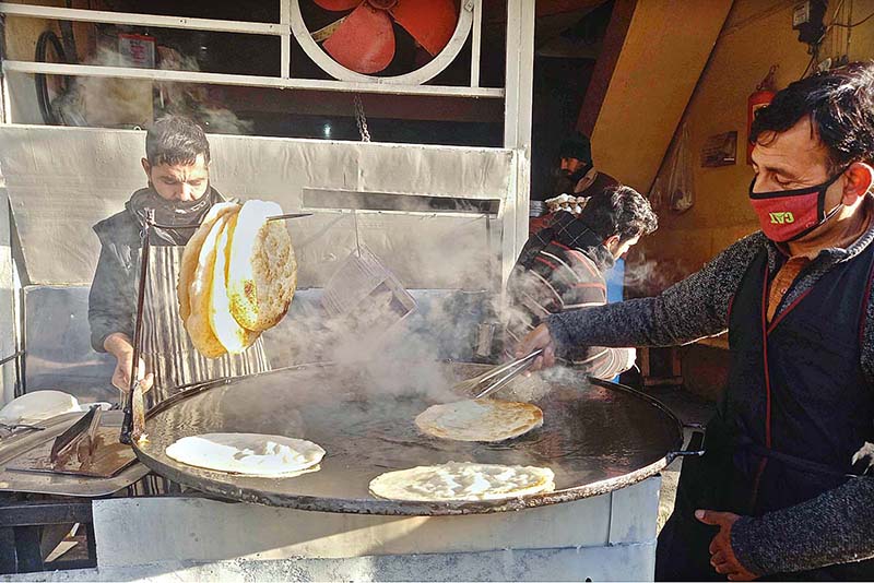 A vendor busy in preparing traditional Parathas at his road side setup to attract customers