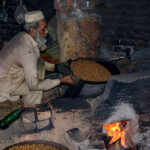 A vendor roasting grams for the customers at his workplace.