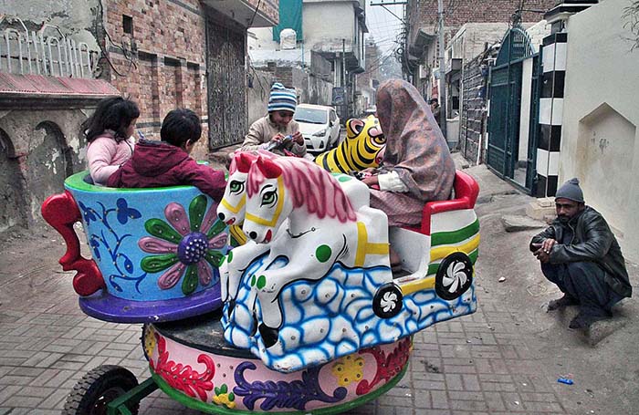 Children enjoy swings in a street.