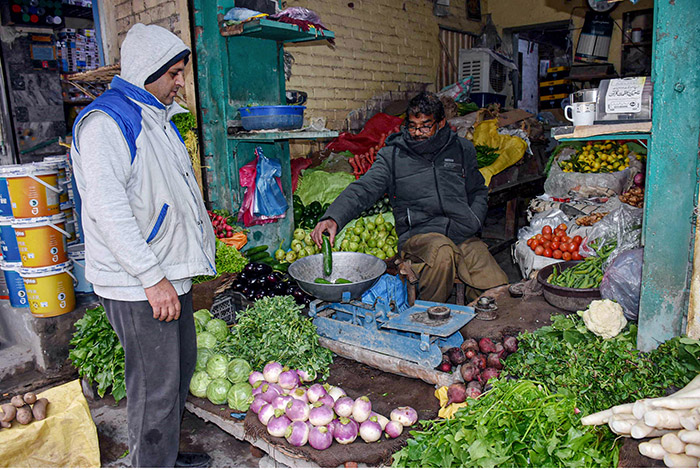 A vendor is selling vegetables to the customer.