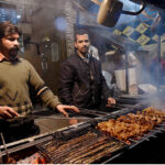 Vendors preparing traditional Chicken Tikka and kabab to attract customers outside their shop at Rustam Park