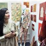 A student viewing creative work during Annual 18th Degree Show at SABS University of Art, Design and Heritages Jamshoro.