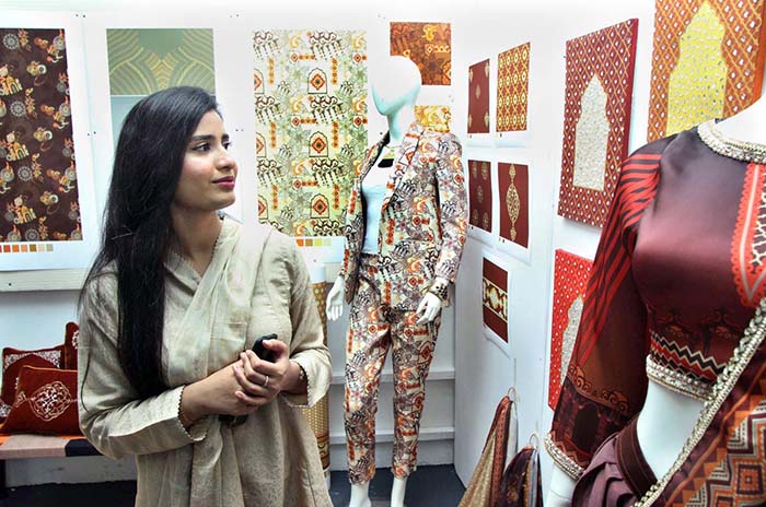 A student viewing creative work during Annual 18th Degree Show at SABS University of Art, Design and Heritages Jamshoro.