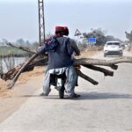 Motorcyclists on the way carrying long tree logs at Miro Khan Road.