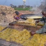 Farmers busy making traditional sweet item (Gurr) on his roadside setup at Kote Fareed Road
