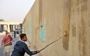 Worker busy paint on wall of Aabpara Underpass in the Federal Capital.