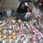 A vendor busy in preparing traditional smoking instrument (Huqqa) top Chilam at his workplace