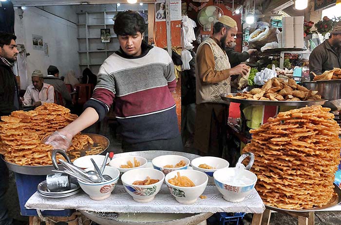 A shopkeeper selling “doodh jalebi” in a local market of Federal Capital.