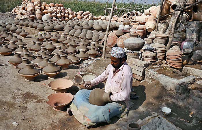 Craftsman preparing clay-made pitchers at his workplace at kumharpara.