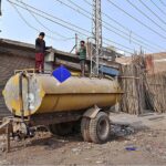 Children flying kites while standing on the water tanker
