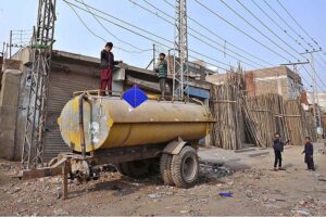Children flying kites while standing on the water tanker