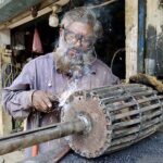 An elderly worker busy in welding work at his workplace.