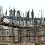 Workers busy in construction work of a flyover bridge on Jhumra Road near Abdullahpur
