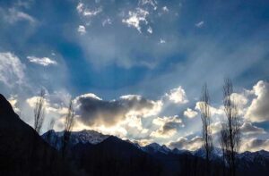 An attractive view of sun rays peeping from the clouds during the sun set in city. 