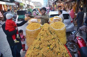 A vendor sells food item to a customer at Fawara Chowk.