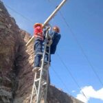 Water and Power department staffer busy in installing new electricity poll at the road side