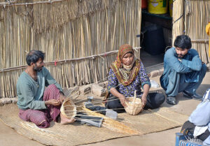 A shopkeeper spreading sacks for drying on the road.