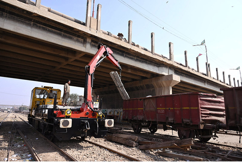 Railway worker unloading concrete Blocks from heavy Crain to lay on railway track near railway station