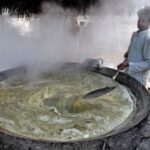 Farmer busy making traditional sweet item (Gurr) at his workplace